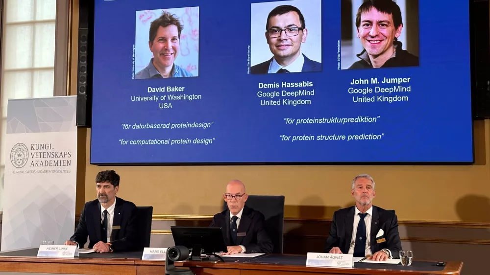 09 October 2024, Sweden, Stockholm: Images of (L-R) David Baker, Demis Hassabis, and John M. Jumper are shown on the screen during the press conference announcing the 2024 Nobel Prize in Chemistry. Half of this year's Nobel Prize in Chemistry goes to David Baker (USA), the other half to Demis Hassabis and John Jumper, who both work in the UK. Baker receives the prize for computer-aided protein design, Hassabis and Jumper for the prediction of the complex structures of proteins. This was announced by the Royal Swedish Academy of Sciences in Stockholm. Photo: Steffen Trumpf/dpa