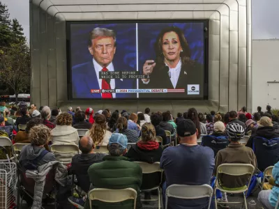 People gather outside of the Berkeley Art Museum and Pacific Film Archive to watch a presidential debate between Republican presidential nominee former President Donald Trump and Democratic presidential nominee Vice President Kamala Harris in Berkeley, Calif., Tuesday, Sept. 10, 2024. (Gabrielle Lurie/San Francisco Chronicle via AP)