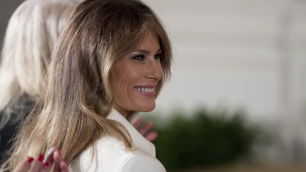 ﻿FILE - This is a Wednesday, March 29, 2017, file photo of U.S. first lady Melania Trump smiles as she is recognized by President Donald Trump as he speaks at a women's empowerment panel, in the East Room of the White House in Washington. Melania Trump on Wednesday April 12, 2017, accepted an apology and damages from the publisher of the Daily Mail newspaper for reporting rumors about her time as a model. (AP Photo/Andrew Harnik, File)