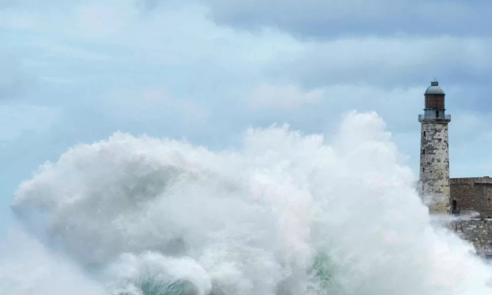 Waves crash over Havana's seafront boulevard El Malecon near a lighthouse as Hurricane Milton passes close to the Cuban coast, Havana, Cuba, October 9, 2024. REUTERS/Norlys Perez   TPX IMAGES OF THE DAY