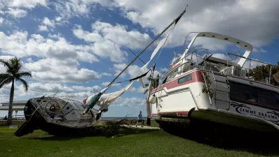 A man walks past boats resting in a public park after they were washed ashore when Hurricane Milton passed through the area, in Punta Gorda, Florida, U.S., October 10, 2024. REUTERS/Ricardo Arduengo