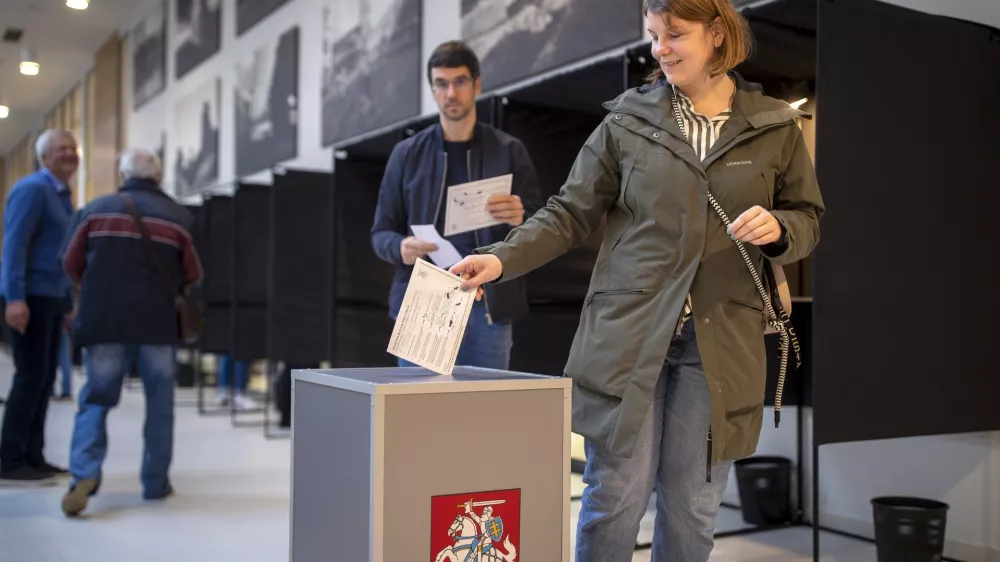 A voter casts his ballot during the advance voting in the first round of a parliamentary election in Vilnius, Lithuania, Wednesday, Oct. 9, 2024. (AP Photo/Mindaugas Kulbis)