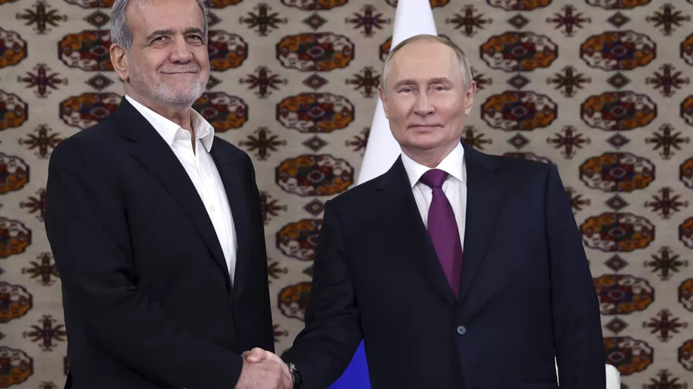 Russian President Vladimir Putin, right, and Iranian President Masoud Pezeshkian pose for a photo during their meeting on the sidelines of the International Forum "The Interconnection of Times and Civilizations – the basis of peace and development" dedicated to the 300th anniversary of the birth of the outstanding Turkmen poet and thinker Magtymguly Fragi in Ashgabat, Turkmenistan, Friday, Oct. 11, 2024. (Alexander Shcherbak, Sputnik, Kremlin Pool Photo via AP)