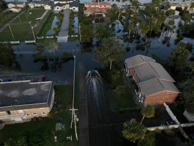 A drone view shows a car driving through a flooded street after Hurricane Milton made landfall in South Daytona, Florida, U.S., October 11, 2024. REUTERS/Ricardo Arduengo   TPX IMAGES OF THE DAY