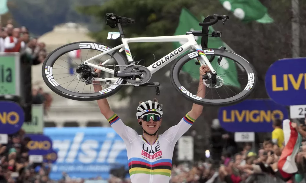 Reigning World Champion Slovenia's Tadej Pogacar holds up his bike as he celebrates winning Il Lombardia, Tour of Lombardy cycling race, in Como, Italy, Saturday, Oct. 12, 2024. (Gian Mattia D'Alberto/LaPresse via AP)