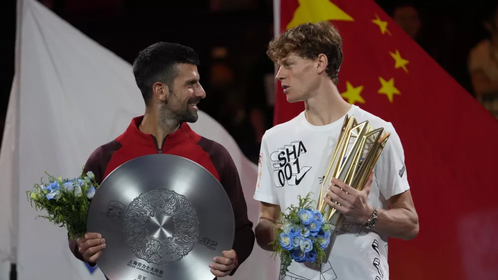 Jannik Sinner of Italy, right, chats with Novak Djokovic of Serbia during a trophy ceremony after their men's singles finals match for the Shanghai Masters tennis tournament at Qizhong Forest Sports City Tennis Center in Shanghai, China, Sunday, Oct. 13, 2024. (AP Photo/Andy Wong)