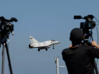 A member of the media takes a video of a Taiwan Air Force Mirage 2000 aircraft preparing to land at Hsinchu Air Base in Hsinchu, Taiwan October 14, 2024. REUTERS/Tyrone Siu