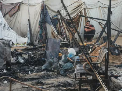 A Palestinian man looks on next to the damage at the site of an Israeli strike on tents sheltering displaced people, amid the Israel-Hamas conflict, at Al-Aqsa Martyrs hospital in Deir Al-Balah in the central Gaza Strip, October 14, 2024. REUTERS/Ramadan Abed   TPX IMAGES OF THE DAY