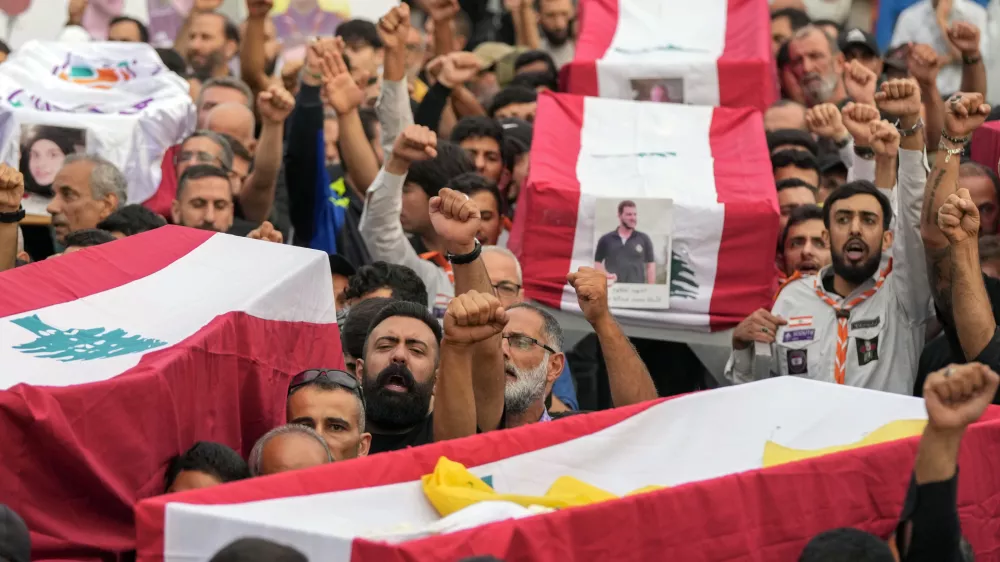 Mourners carry the coffins of their relatives, killed on Saturday in an Israeli airstrike, during their funeral procession in Maisara near the northern coastal town of Byblos, Lebanon, Monday, Oct. 14, 2024. (AP Photo/Hassan Ammar)