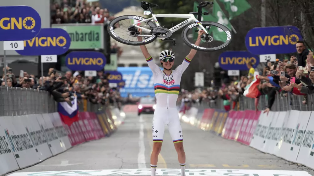 Reigning World Champion Slovenia's Tadej Pogacar holds up his bike as he celebrates winning Il Lombardia, Tour of Lombardy cycling race, in Como, Italy, Saturday, Oct. 12, 2024. (Gian Mattia D'Alberto/LaPresse via AP)