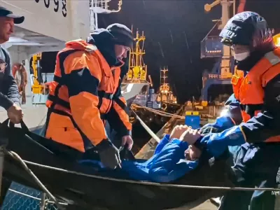 In this photo taken from video released by Russian Emergency Ministry Press Service on Tuesday, Oct. 15, 2024, Russian emergency workers pull Mikhail Pichugin ashore after he was rescued by a fishing vessel following 67 days adrift in the Sea of Okhotsk near the village of Ust-Khairuzovo in Kamchatka region of Russian far east. (Russian Emergency Ministry Press Service via AP)