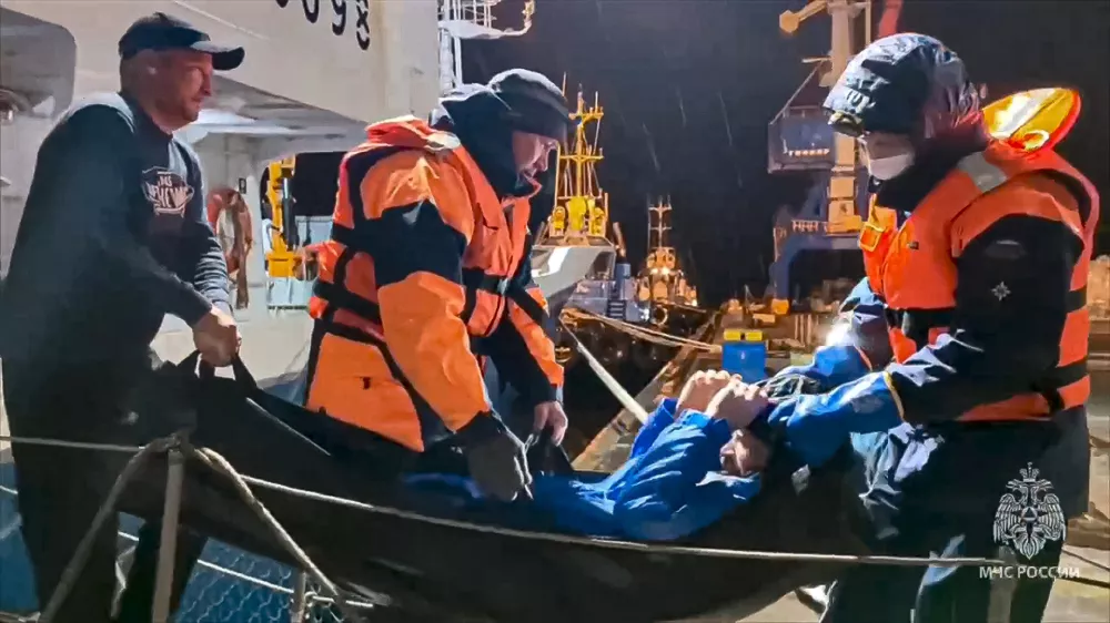 In this photo taken from video released by Russian Emergency Ministry Press Service on Tuesday, Oct. 15, 2024, Russian emergency workers pull Mikhail Pichugin ashore after he was rescued by a fishing vessel following 67 days adrift in the Sea of Okhotsk near the village of Ust-Khairuzovo in Kamchatka region of Russian far east. (Russian Emergency Ministry Press Service via AP)