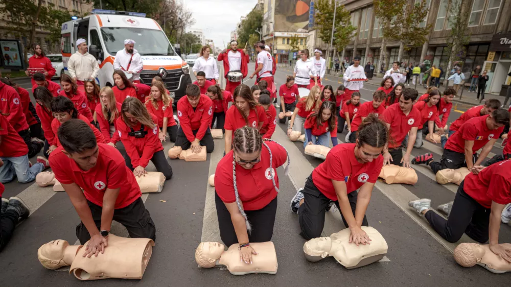 Romanian Red Cross volunteers perform resuscitation on mannequins during a flash mob to mark the World Restart a Heart Day in Bucharest, Romania, Wednesday, Oct. 16, 2024. (AP Photo/ Andreea Alexandru)