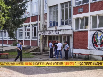 Police officers stand in front of a secondary school building in Sanski Most, northwest of Bosnia's capital, Sarajevo, Wednesday, Aug. 21, 2024, after a school employee shot and killed three people. (AP Photo/Edvin Zulic)