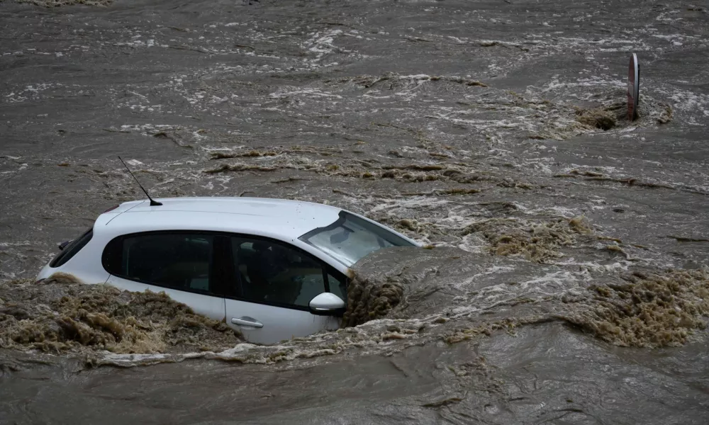 17 October 2024, France, Givors: A flooded car stands in an industrial estate after heavy rainfall in the region. Photo: Jean-Philippe Ksiazek/AFP/dpa