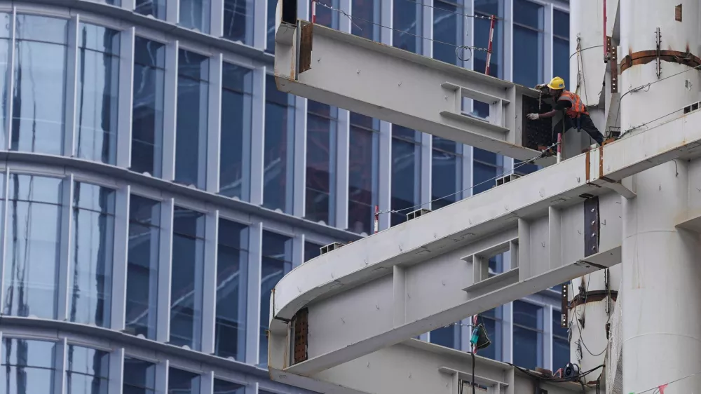 FILE PHOTO: A worker works on a building under construction in Beijing's Central Business District (CBD), China July 14, 2024. REUTERS/Tingshu Wang/File Photo