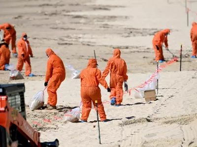 Workers in protective clothing clean up unknown debris washed up on Coogee Beach, Sydney, Australia October 17, 2024. AAP Image/Dan Himbrechts via REUTERS ATTENTION EDITORS - THIS IMAGE WAS PROVIDED BY A THIRD PARTY. NO RESALES. NO ARCHIVE. AUSTRALIA OUT. NEW ZEALAND OUT. NO COMMERCIAL OR EDITORIAL SALES IN NEW ZEALAND. NO COMMERCIAL OR EDITORIAL SALES IN AUSTRALIA.