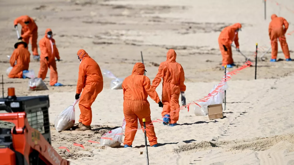 Workers in protective clothing clean up unknown debris washed up on Coogee Beach, Sydney, Australia October 17, 2024. AAP Image/Dan Himbrechts via REUTERS ATTENTION EDITORS - THIS IMAGE WAS PROVIDED BY A THIRD PARTY. NO RESALES. NO ARCHIVE. AUSTRALIA OUT. NEW ZEALAND OUT. NO COMMERCIAL OR EDITORIAL SALES IN NEW ZEALAND. NO COMMERCIAL OR EDITORIAL SALES IN AUSTRALIA.