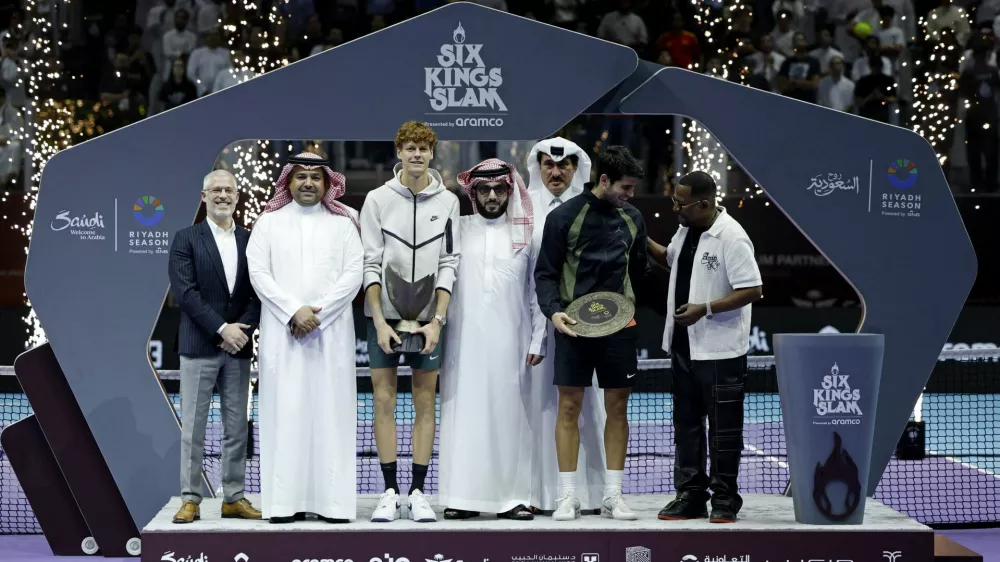 Tennis - 6 Kings Slam - Riyadh, Saudi Arabia - October 19, 2024 Spain's Carlos Alcaraz and Italy's Jannik Sinner are seen on the podium with trophies after the final with Chairman of the General Entertainment Authority, Turki Al-Sheikh and actor Martin Lawrence REUTERS/Hamad I Mohammed