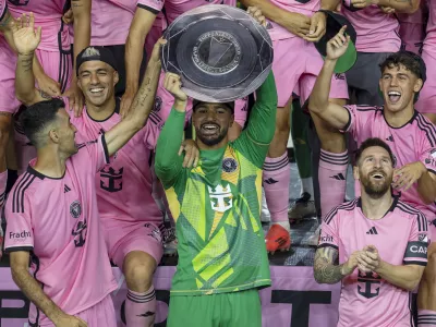 Inter Miami forward Lionel Messi, front right, celebrates with his teammates Sergio Busquets, front left, Luis Suárez, second row, left, and Drake Callender, center in green, after winning the Supporters' Shield defeating the New England Revolution at Chase Stadium in Fort Lauderdale, Fla., Saturday, Oct. 19, 2024. (David Santiago/Miami Herald via AP)