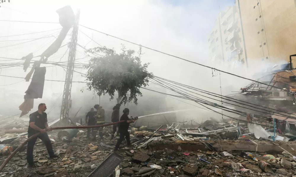 Civil defence members put out a fire at a damaged site, in the aftermath of Israeli strikes on Beirut's southern suburbs, Lebanon October 20, 2024. REUTERS/Ali Alloush REFILE - QUALITY REPEAT   TPX IMAGES OF THE DAY