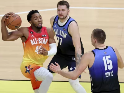 Team Giannis guard Donovan Mitchell (45) drives past Team LeBron forward Luka Doncic (77) and Team LeBron center Nikola Jokic (15) during the first half of the NBA basketball All-Star game Sunday, Feb. 19, 2023, in Salt Lake City. (AP Photo/Rob Gray)