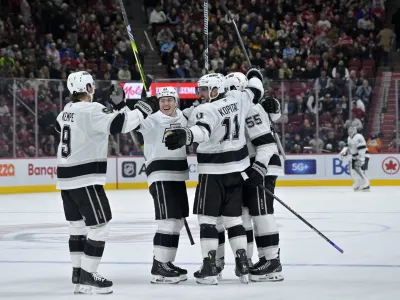 Oct 17, 2024; Montreal, Quebec, CAN; Los Angeles Kings defenseman Andreas Englund (5) celebrates with teammates including forward Anze Kopitar (11) and forward Adrian Kempe (9) after scoring a goal against the Montreal Canadiens during the third period at the Bell Centre. Mandatory Credit: Eric Bolte-Imagn Images