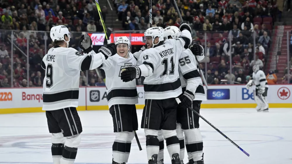 Oct 17, 2024; Montreal, Quebec, CAN; Los Angeles Kings defenseman Andreas Englund (5) celebrates with teammates including forward Anze Kopitar (11) and forward Adrian Kempe (9) after scoring a goal against the Montreal Canadiens during the third period at the Bell Centre. Mandatory Credit: Eric Bolte-Imagn Images