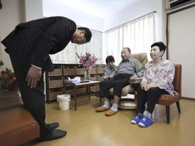 Shizuoka Prefectural Police chief Takayoshi Tsuda, left, offers an apology to former Japanese death-row inmate Iwao Hakamada, center, and his sister Hideko, right, for his decades-long suffering, at Hakamada's home in Hamamatsu, Shizuoka prefecture, central Japan, Monday, Oct. 21, 2024. (Kyodo News via AP)