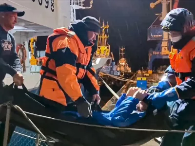 In this photo taken from video released by Russian Emergency Ministry Press Service on Tuesday, Oct. 15, 2024, Russian emergency workers pull Mikhail Pichugin ashore after he was rescued by a fishing vessel following 67 days adrift in the Sea of Okhotsk near the village of Ust-Khairuzovo in Kamchatka region of Russian far east. (Russian Emergency Ministry Press Service via AP)