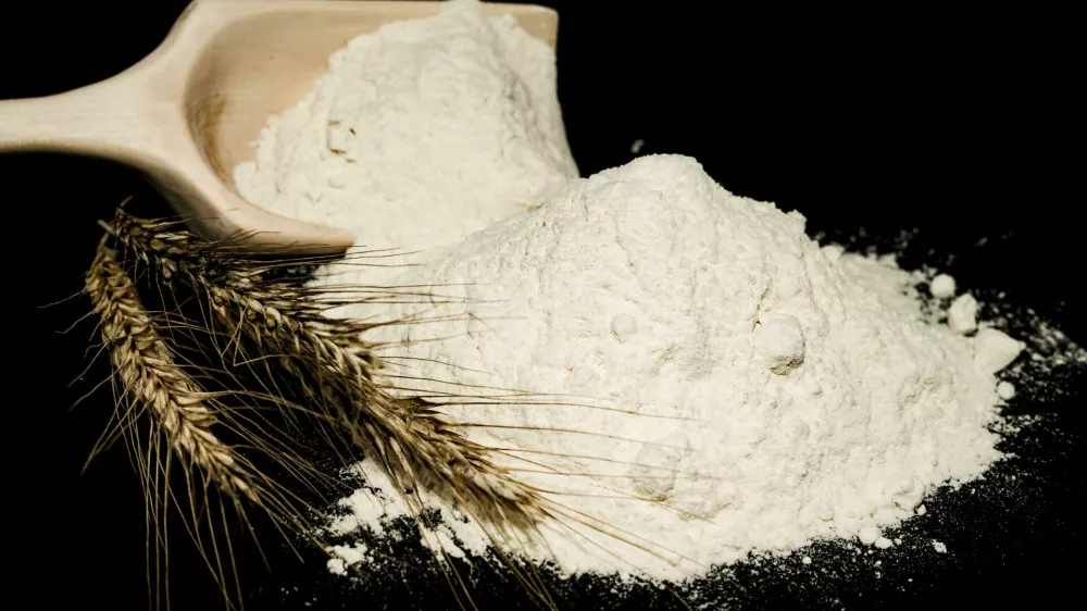 2GD2JPX Flour. Scoop with flour and wheat ears close up on black background Foto: Reuters/Alamy