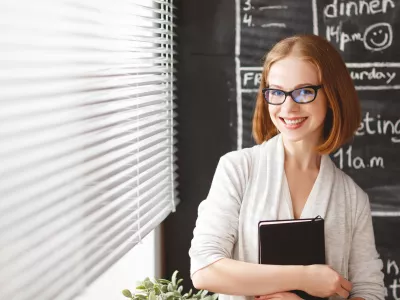 Happy businesswoman woman at school board with schedule planning and notepad