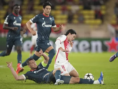 Monaco's Takumi Minamino, right, and Red Star's Uros Spajic fight for the ball during the Champions League opening phase soccer match between Monaco and Crvena Zvezda, Red Star Belgrade, at the Louis II stadium, in Monaco, Tuesday, Oct. 22, 2024. (AP Photo/Laurent Cipriani)