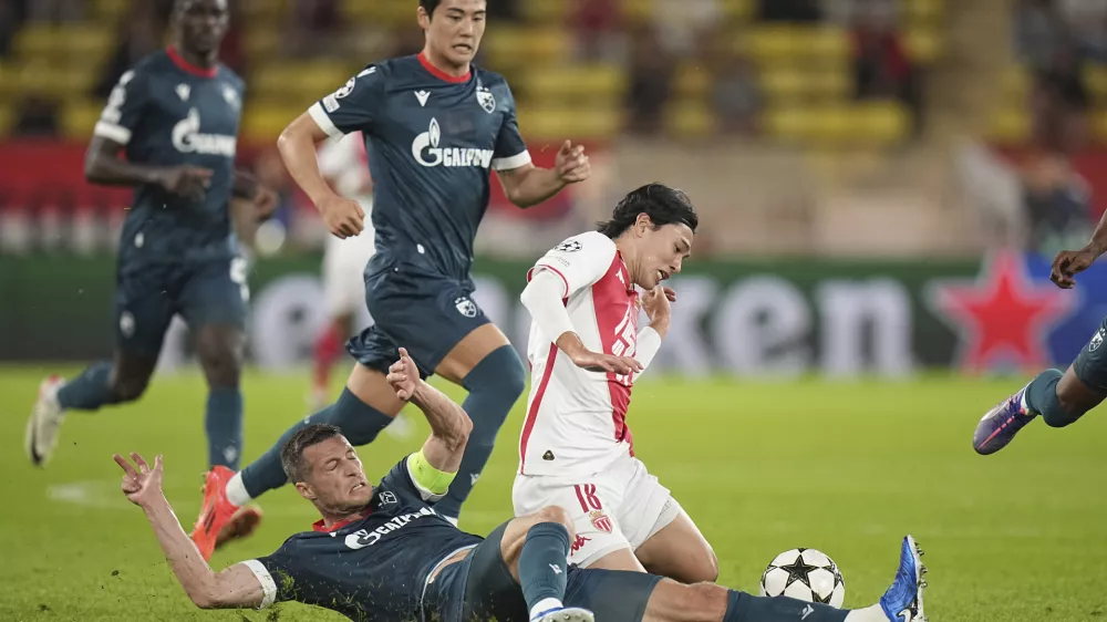 Monaco's Takumi Minamino, right, and Red Star's Uros Spajic fight for the ball during the Champions League opening phase soccer match between Monaco and Crvena Zvezda, Red Star Belgrade, at the Louis II stadium, in Monaco, Tuesday, Oct. 22, 2024. (AP Photo/Laurent Cipriani)