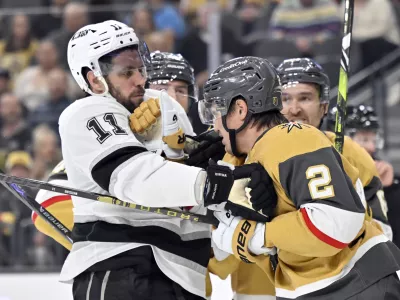 Los Angeles Kings center Anze Kopitar (11) and Vegas Golden Knights defenseman Zach Whitecloud (2) get into scuffle during the third period of an NHL hockey game Tuesday, Oct. 22, 2024, in Las Vegas. (AP Photo/David Becker)