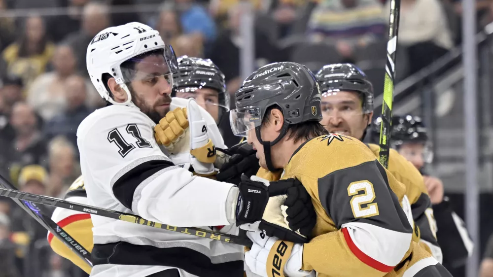 Los Angeles Kings center Anze Kopitar (11) and Vegas Golden Knights defenseman Zach Whitecloud (2) get into scuffle during the third period of an NHL hockey game Tuesday, Oct. 22, 2024, in Las Vegas. (AP Photo/David Becker)