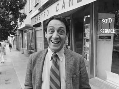 (Original Caption) 11/9/1977-San Francisco: Supervisor Harvey Milk poses outside his camera shop after his 1977 election to the Board of Supervisors. Milk and Mayor George Moscone were assassinated at City Hall by resigned supervisor Dan White. / Foto: Bettmann