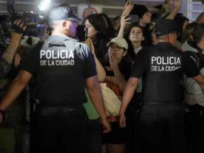 Police restrain fans gathering outside the hotel where former One Direction singer Liam Payne was found dead after he fell from a balcony in Buenos Aires, Argentina, Wednesday, Oct. 16, 2024. (AP Photo/Natacha Pisarenko)