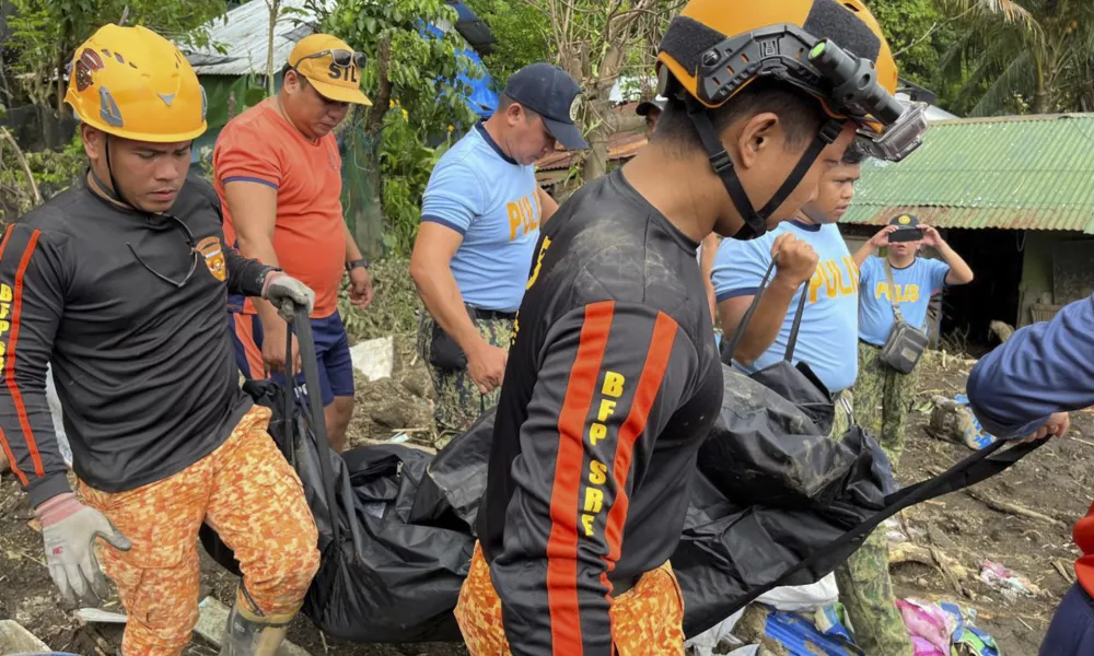 Rescuers carry a body during retrieval operations after a landslide triggered by Tropical Storm Trami, struck homes in Talisay, Batangas province, Philippines, Saturday, Oct. 26, 2024. (AP Photo/Jim Gomez)