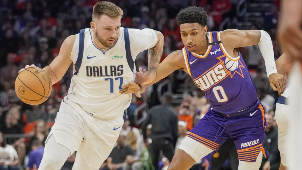 Dallas Mavericks guard Luka Doncic (77) drives past Phoenix Suns forward Ryan Dunn (0) during the first half of an NBA basketball game Saturday, Oct. 26, 2024, in Phoenix. (AP Photo/Darryl Webb)