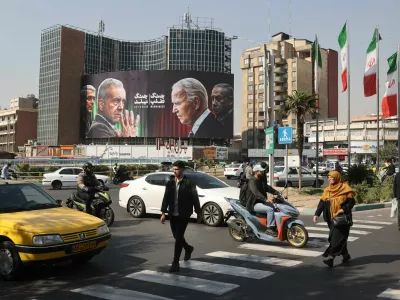 Iranians walk next to an anti-U.S. and Israeli billboard with pictures of Iranian President Masoud Pezeshkian and Iranian Armed Forces Chief of Staff, Major General Mohammad Bagheri and U.S. President Joe Biden and Israel's Prime Minister Benjamin Netanyahu, on a street in Tehran, Iran, October 27, 2024. Majid Asgaripour/WANA (West Asia News Agency) via REUTERS ATTENTION EDITORS - THIS IMAGE HAS BEEN SUPPLIED BY A THIRD PARTY  ATTENTION EDITORS - THIS PICTURE WAS PROVIDED BY A THIRD PARTY