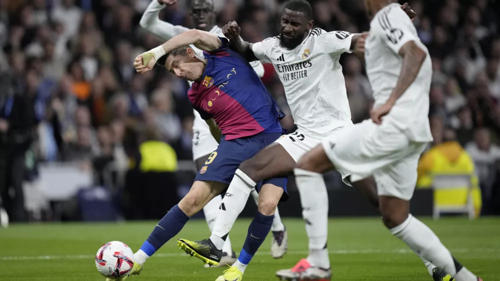 Barcelona's Robert Lewandowski fights for the ball during a Spanish La Liga soccer match between Real Madrid and Barcelona at the Santiago Bernabeu stadium in Madrid, Spain, Saturday, Oct. 26, 2024. (AP Photo/Bernat Armangue)