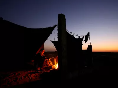 Displaced Palestinian light a fire next to their tent as they live at a cemetery, amid the Israel-Hamas conflict, in Khan Younis, in the southern Gaza Strip, October 27, 2024. REUTERS/Mohammed Salem