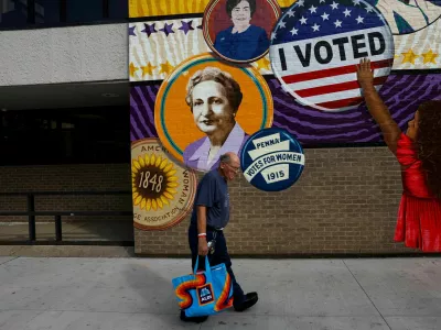 A man walks by a mural in the election battleground city of Erie, Pennsylvania, U.S., October 23, 2024. REUTERS/Shannon Stapleton