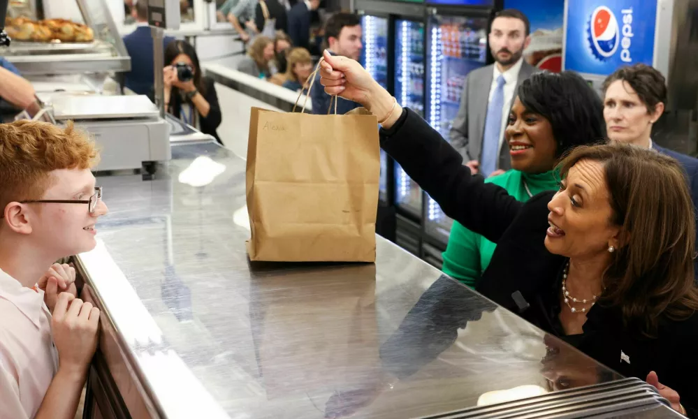 Democratic presidential nominee U.S. Vice President Kamala Harris holds a bag at the Famous 4th Street Delicatessen in Philadelphia, Pennsylvania, U.S., October 23, 2024. REUTERS/Kevin Mohatt