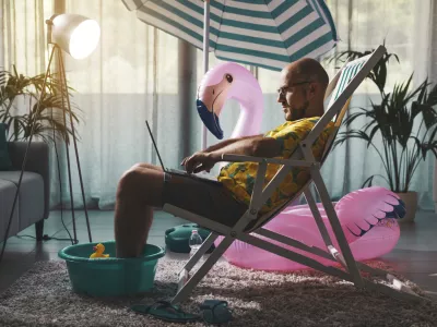 Delo od doma, Man spending summer vacations at home alone, he is sitting on the deckchair in the living room and working with a laptop