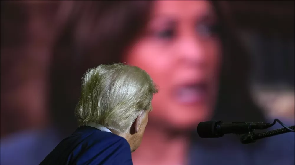 Republican presidential nominee former President Donald Trump watches a video featuring Democratic presidential nominee Vice President Kamala Harris as he speaks at a campaign rally at PPL Center, Tuesday, Oct. 29, 2024, in Allentown, Pa. (AP Photo/Julia Demaree Nikhinson)