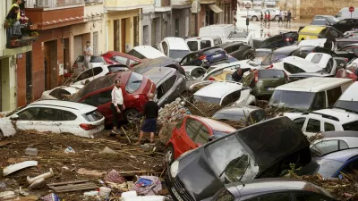 Residents look at cars piled up after being swept away by floods in Valencia, Spain, Wednesday, Oct. 30, 2024. (AP Photo/Alberto Saiz)