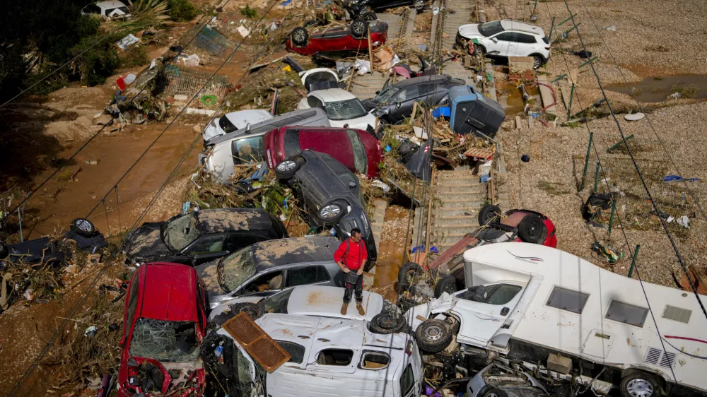 A man stands among flooded cars piled up in Valencia, Spain, Thursday, Oct. 31, 2024. (AP Photo/Manu Fernandez)