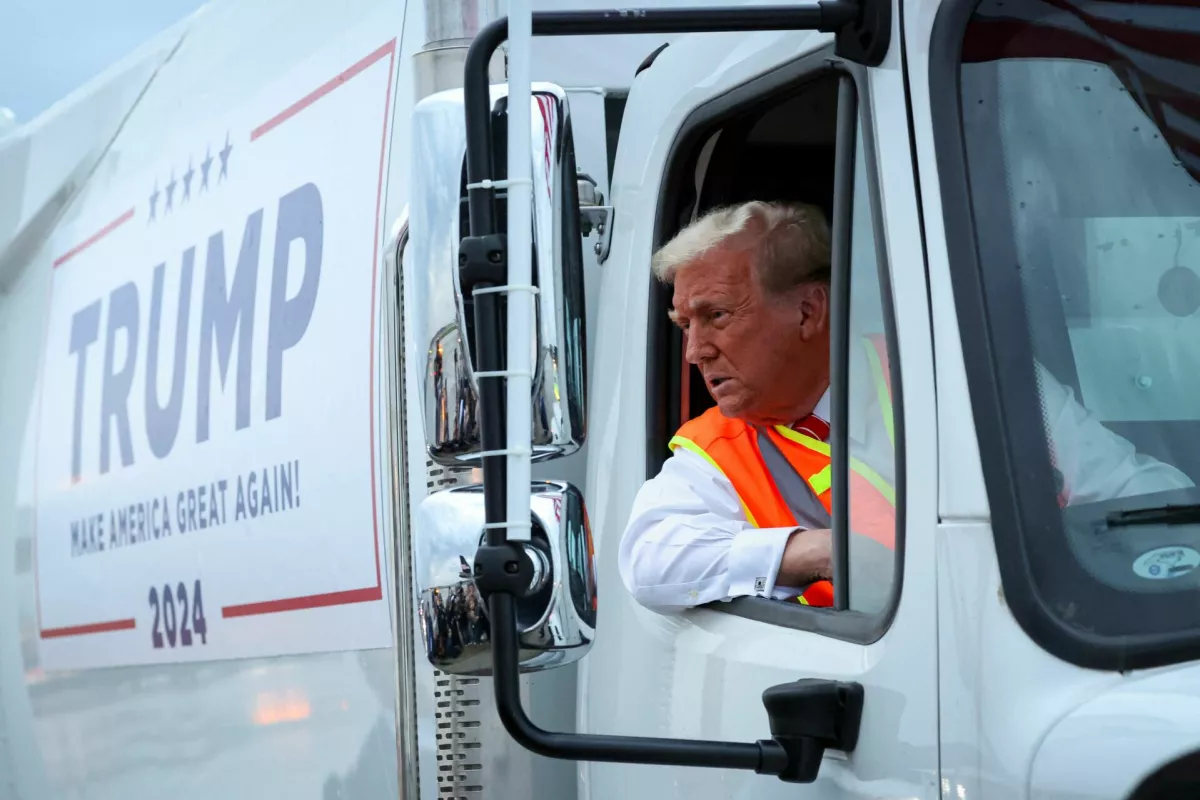 Republican presidential nominee and former U.S. President Donald Trump sits inside garbage truck as he wears a high-vis vest, on tarmac at Green Bay Austin Straubel International Airport in Green Bay, Wisconsin, U.S., October 30, 2024. REUTERS/Brendan McDermid